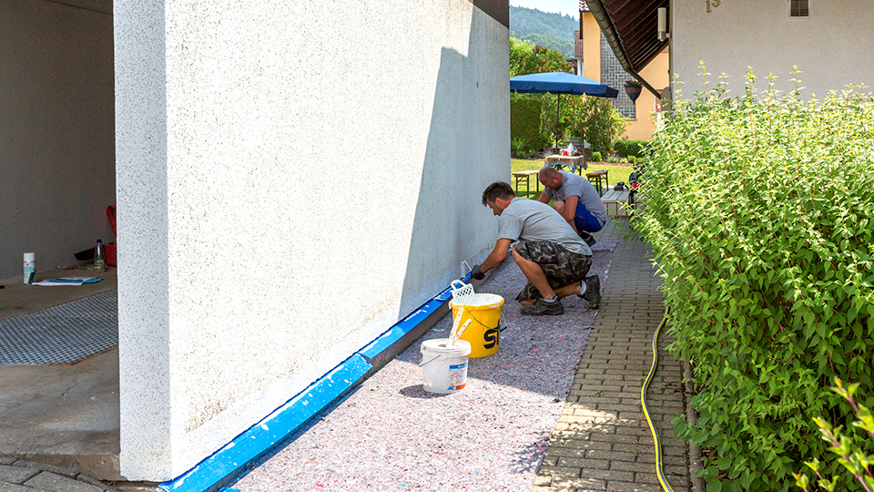 Außenwand einer Betonfertiggarage wird saniert – Garagenrenovierung mit Putz und Farbe als Alternative zum Neubau